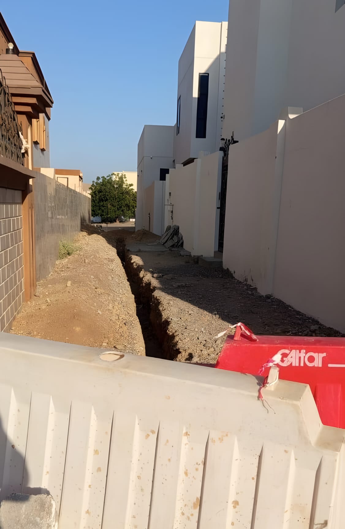 خندق مفتوح على طول زقاق سكني، والحواجز في مكانها
