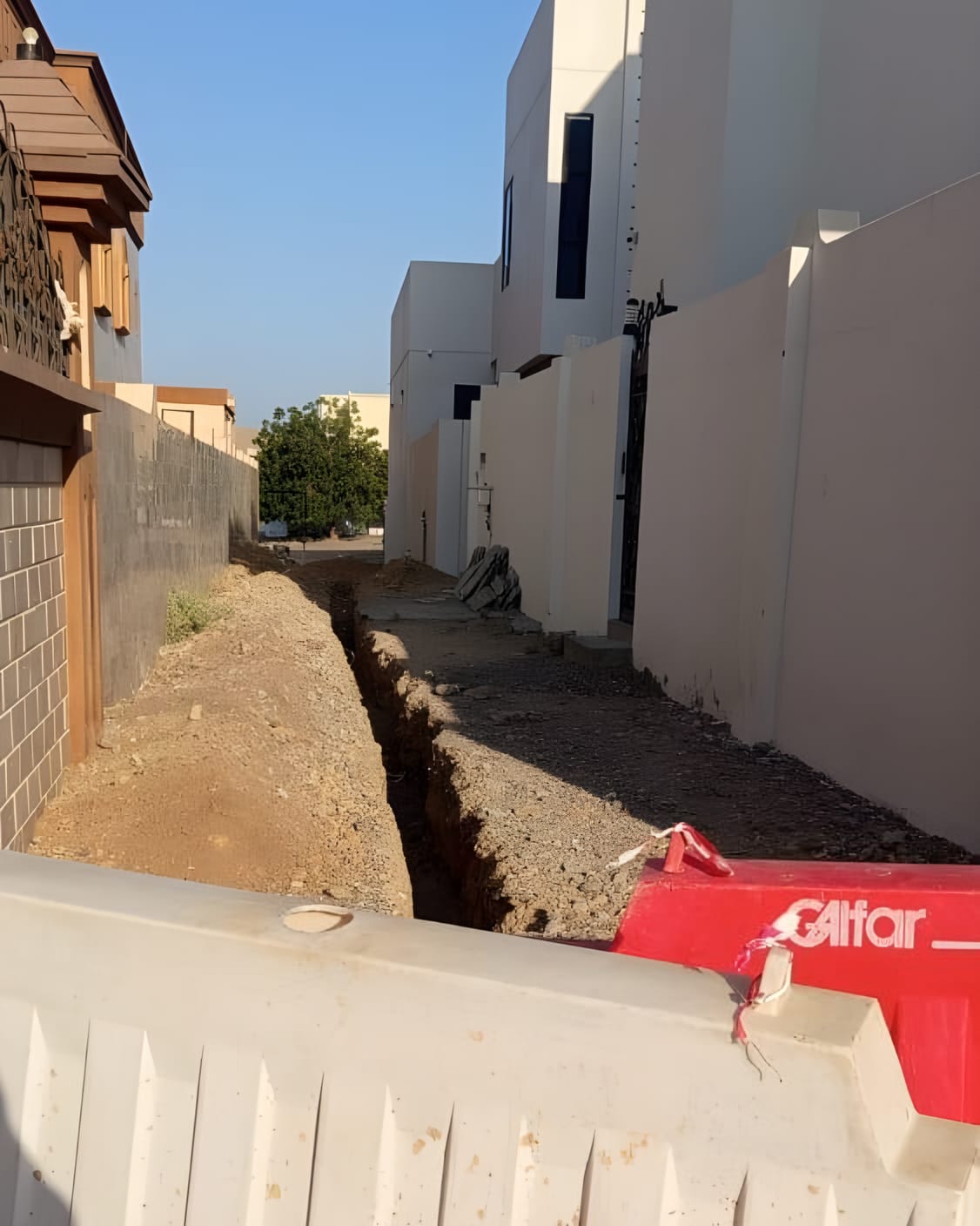 خندق مفتوح على طول زقاق سكني، والحواجز في مكانها