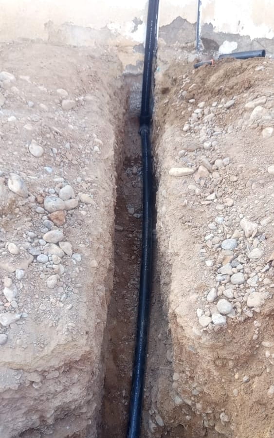 New HDPE service line on its bed in the trench